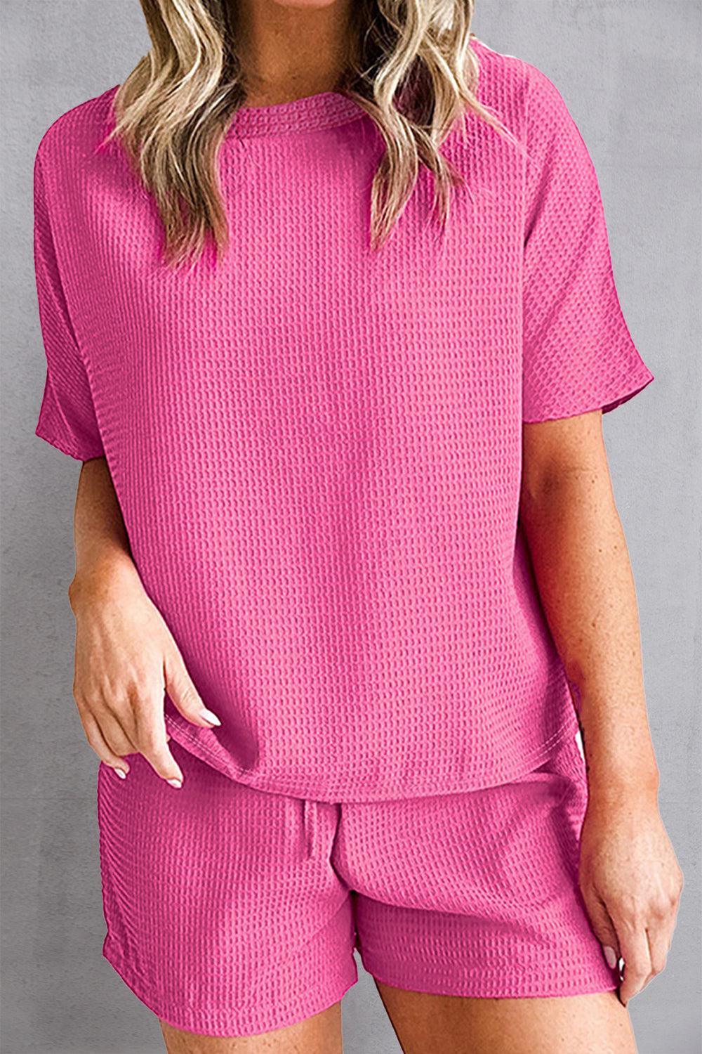 a woman wearing a pink top and shorts