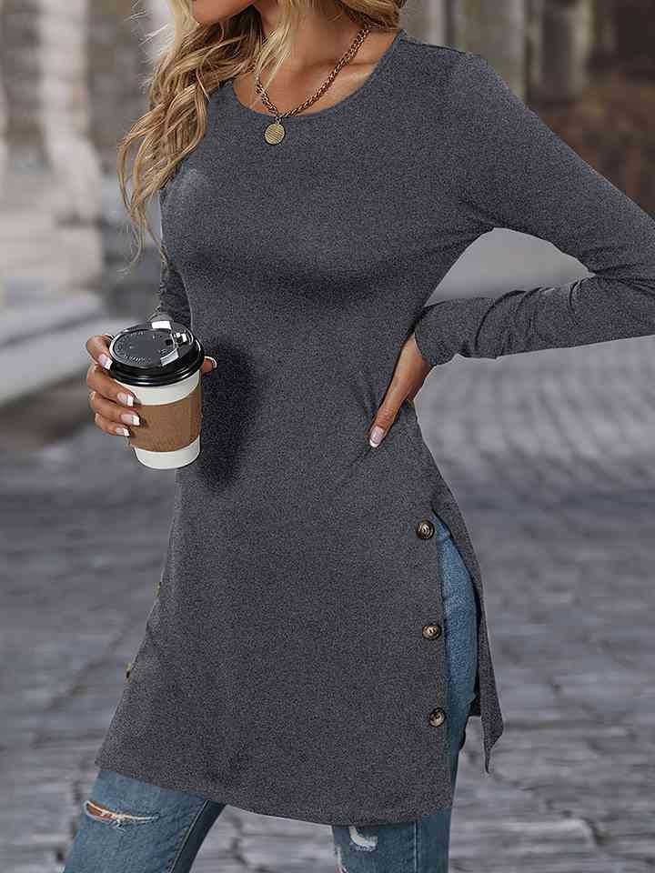 a woman holding a cup of coffee and wearing a gray top