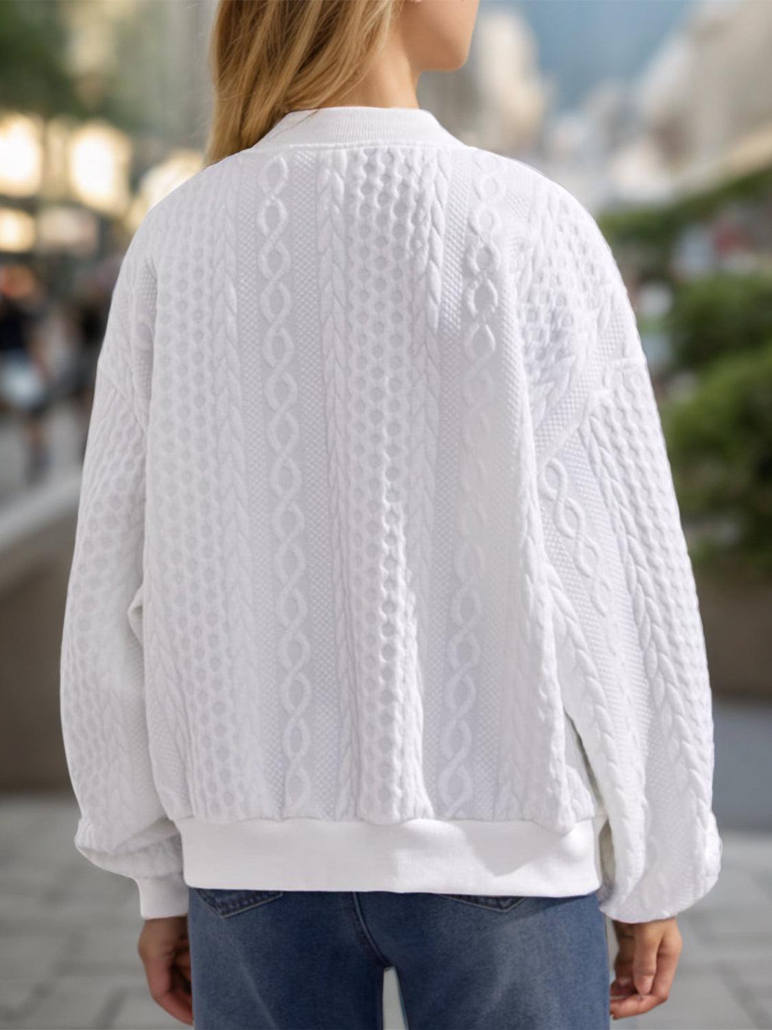 a woman wearing a white sweater and jeans