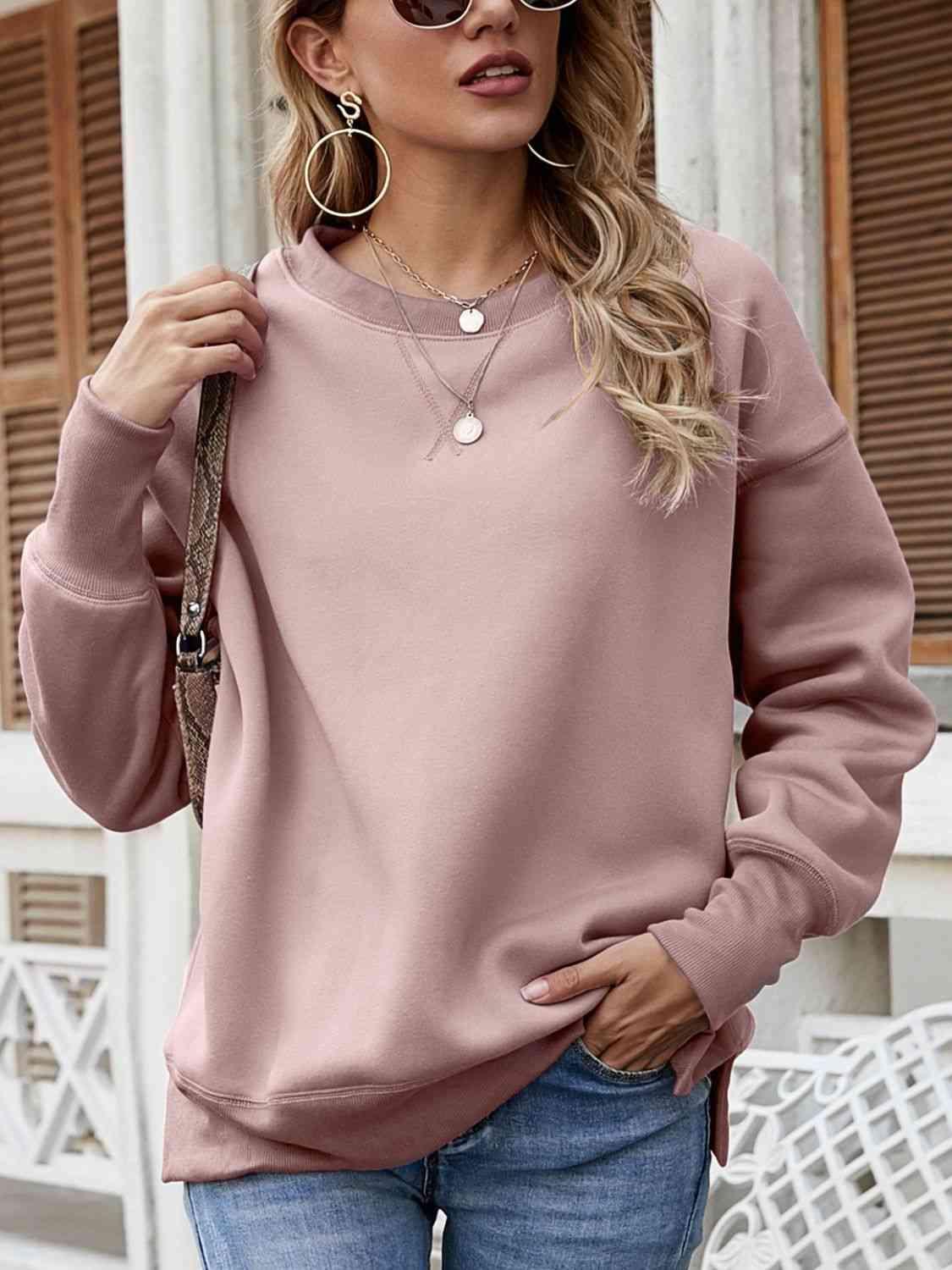 a woman wearing a pink sweater and jeans
