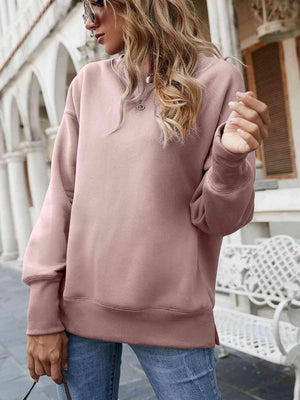 a woman wearing a pink sweatshirt and jeans