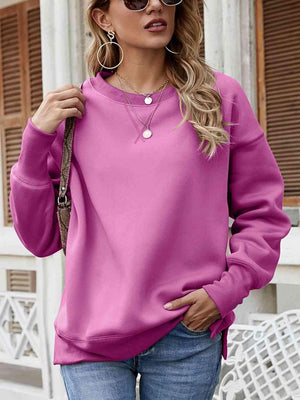 a woman wearing a pink sweater and jeans