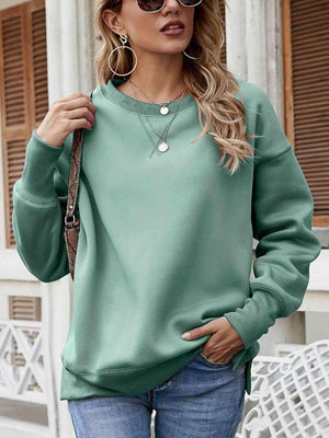 a woman wearing a green sweatshirt and jeans