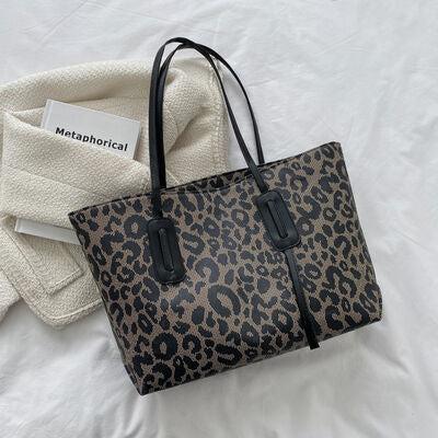 a leopard print bag sitting on top of a bed