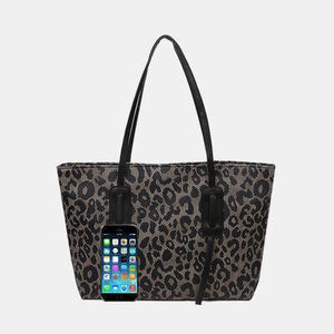 an animal print bag with a cell phone in it