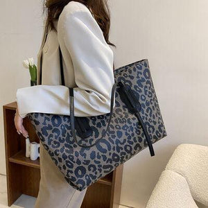 a woman carrying a blue leopard print bag