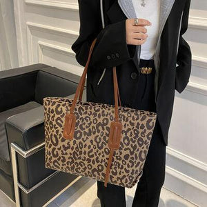 a woman holding a leopard print purse