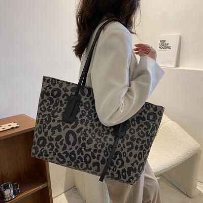 a woman carrying a gray and black leopard print tote bag