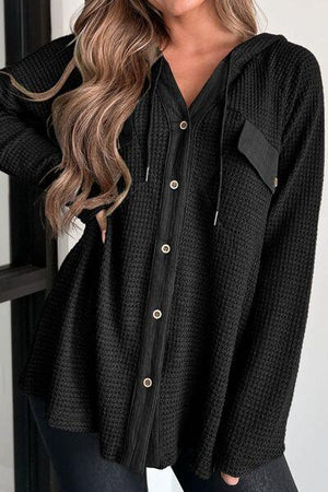 a woman wearing a black sweater and jeans