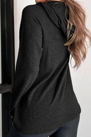 a woman wearing a black sweater and black pants