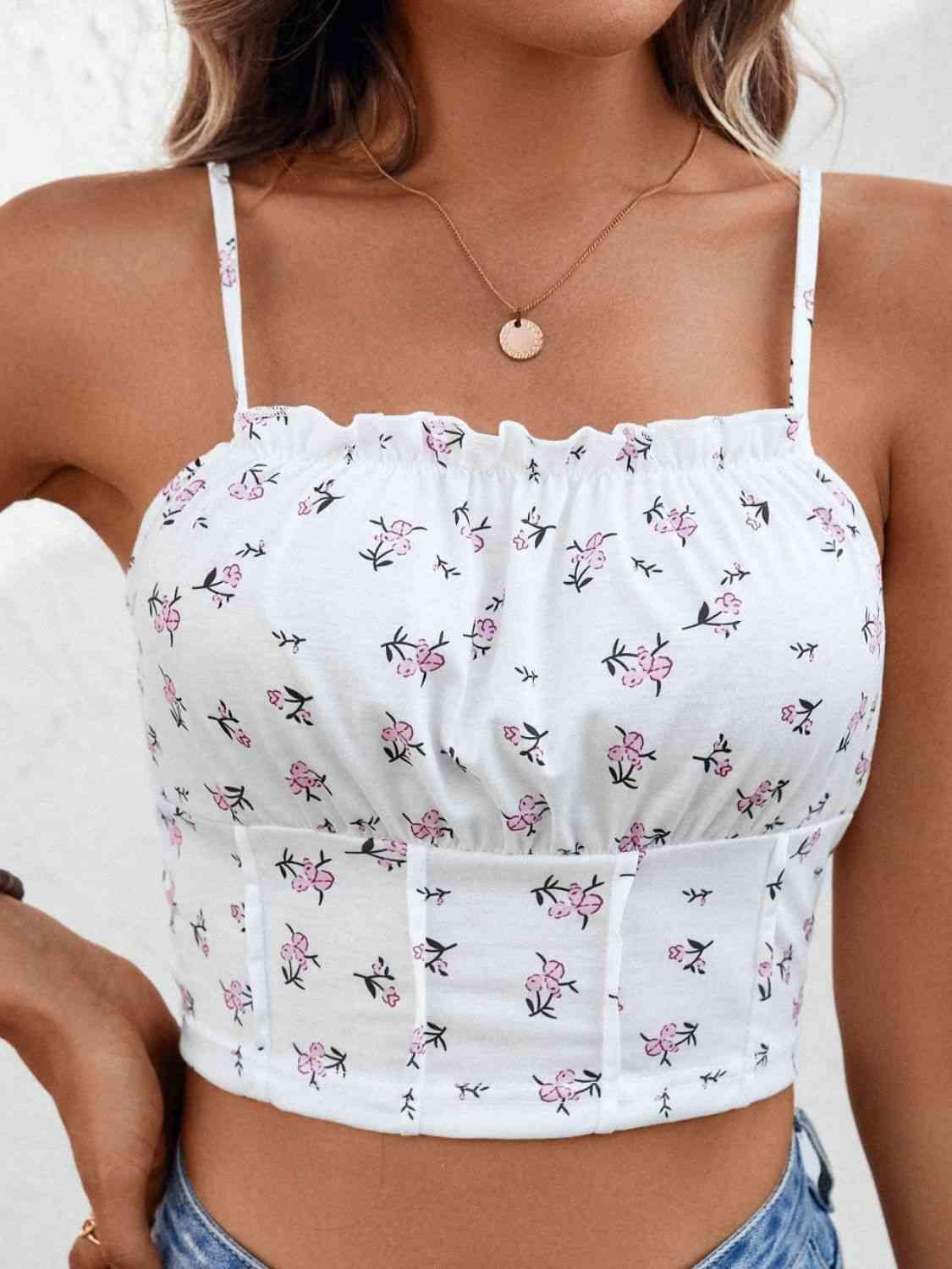a woman wearing a white top with pink flowers on it