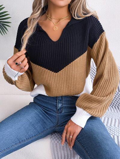 a woman sitting on a couch wearing a sweater and jeans