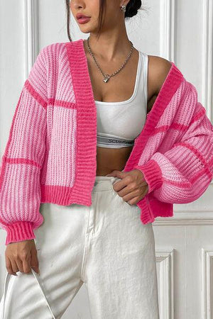 a woman wearing a pink sweater and white pants