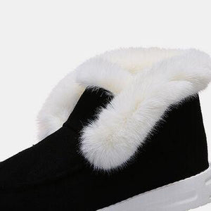 a pair of black and white slippers with white fur
