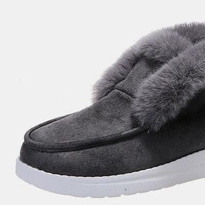 a pair of black slippers with fur on them