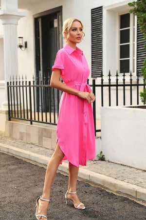 a woman in a pink dress is walking down the street