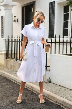 a woman wearing a white shirt dress and heels