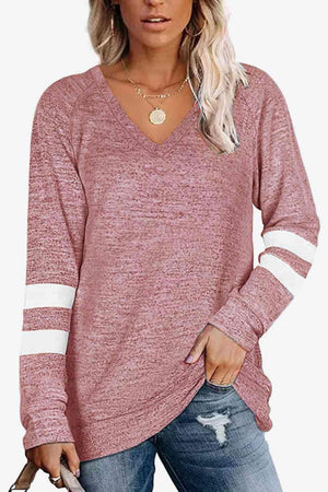 a woman wearing a pink sweater and ripped jeans