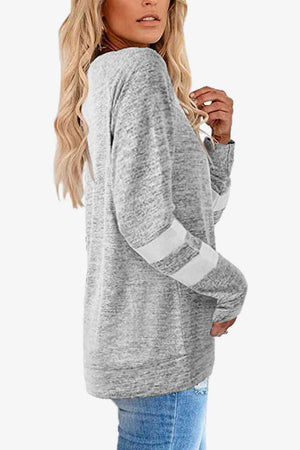 a woman wearing a grey sweater and jeans