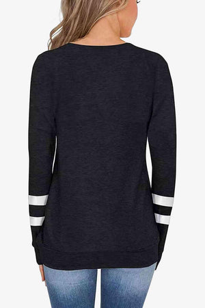 a woman wearing a black sweater with white stripes