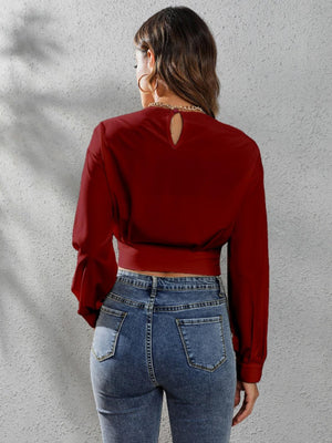 a woman wearing a red top and jeans