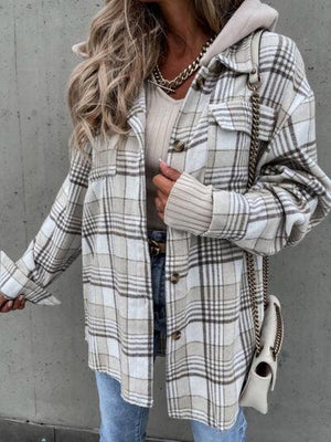 a woman wearing a plaid jacket and jeans