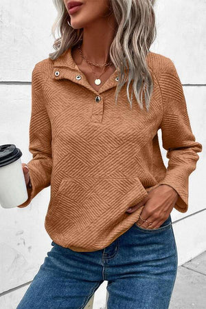 a woman wearing a brown sweater and jeans