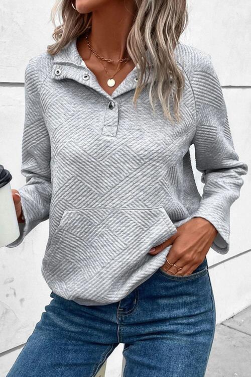 a woman wearing a gray sweater and jeans