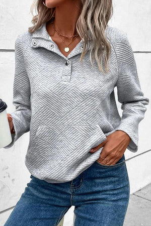 a woman wearing a gray sweater and jeans