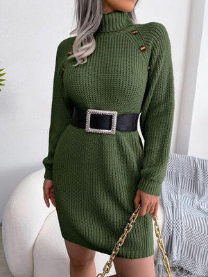 a woman in a green sweater dress holding a handbag