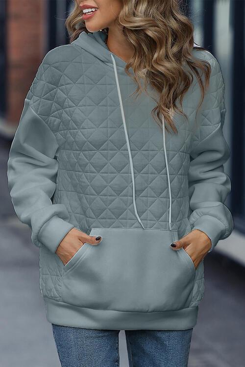 a woman wearing a gray quilted hoodie