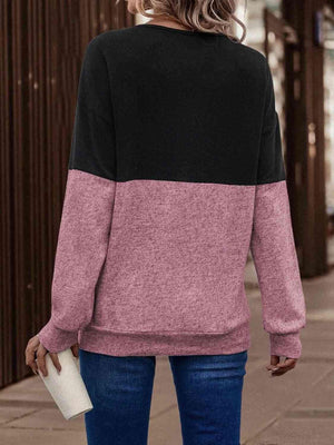 a woman wearing a black and pink sweater