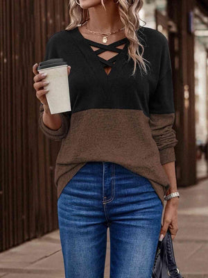 a woman holding a cup of coffee and wearing a sweater