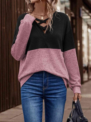 a woman wearing a black and pink sweater and jeans