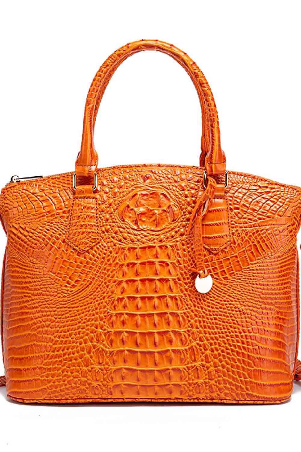 an orange alligator skin handbag on a white background