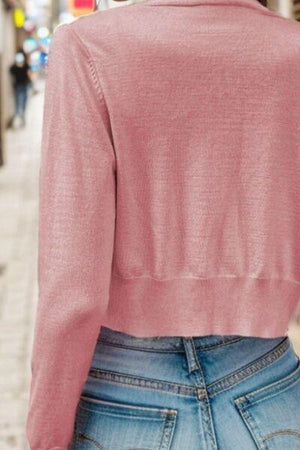 a woman wearing a pink sweater and jeans