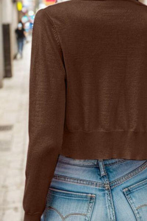 a woman wearing a brown sweater and jeans