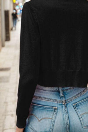 a woman in a black top is walking down the street