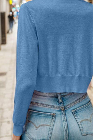 the back of a woman's blue sweater on a city street