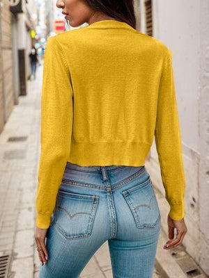 a woman wearing a yellow sweater and jeans