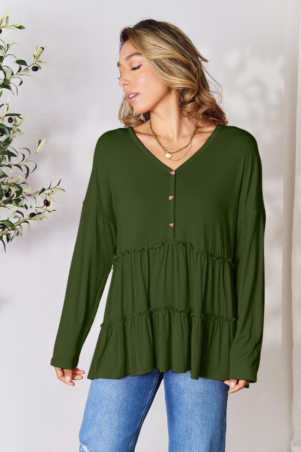 a woman wearing a green top and jeans