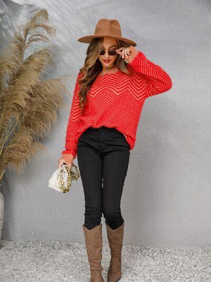 a woman wearing a red sweater and black pants