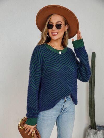 a woman wearing a green and blue sweater and hat