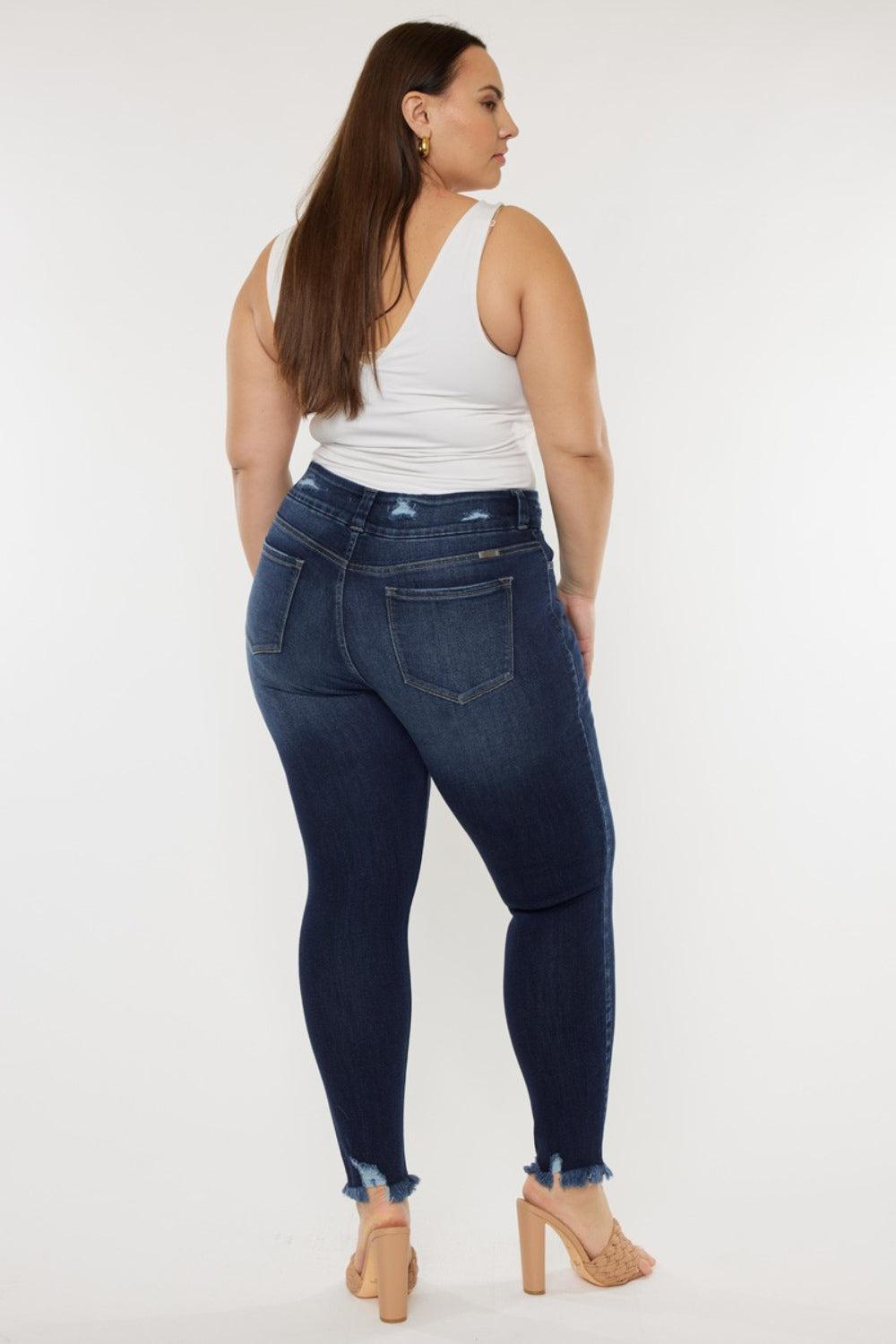 a woman in a white tank top and jeans