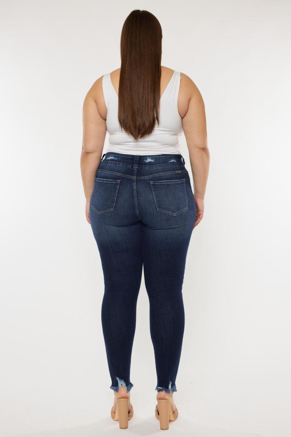 a woman in a white tank top and jeans