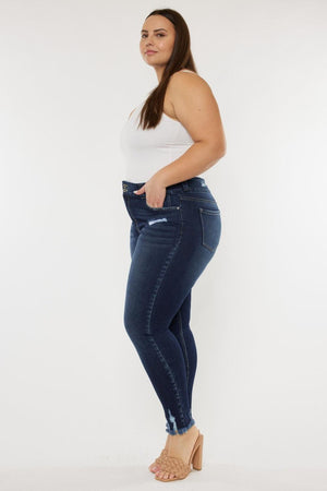 a woman in a white tank top and jeans