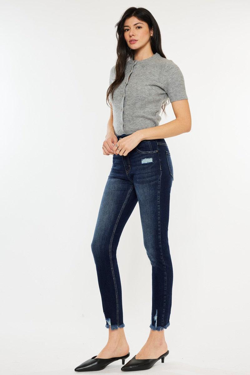 a woman in grey shirt and jeans posing for a picture