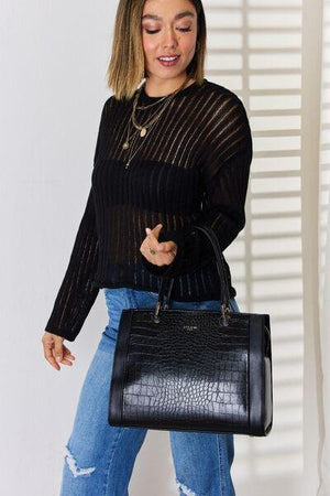 a woman holding a black handbag in her right hand