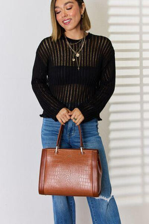 a woman is holding a brown handbag