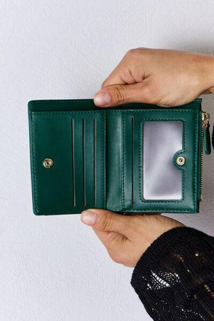 a person holding a green wallet in their hand